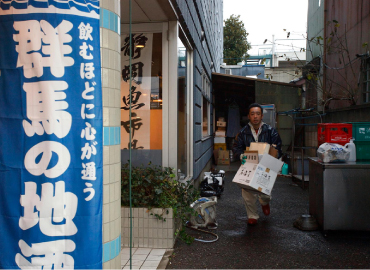 路地の奥からゴミを持って走る